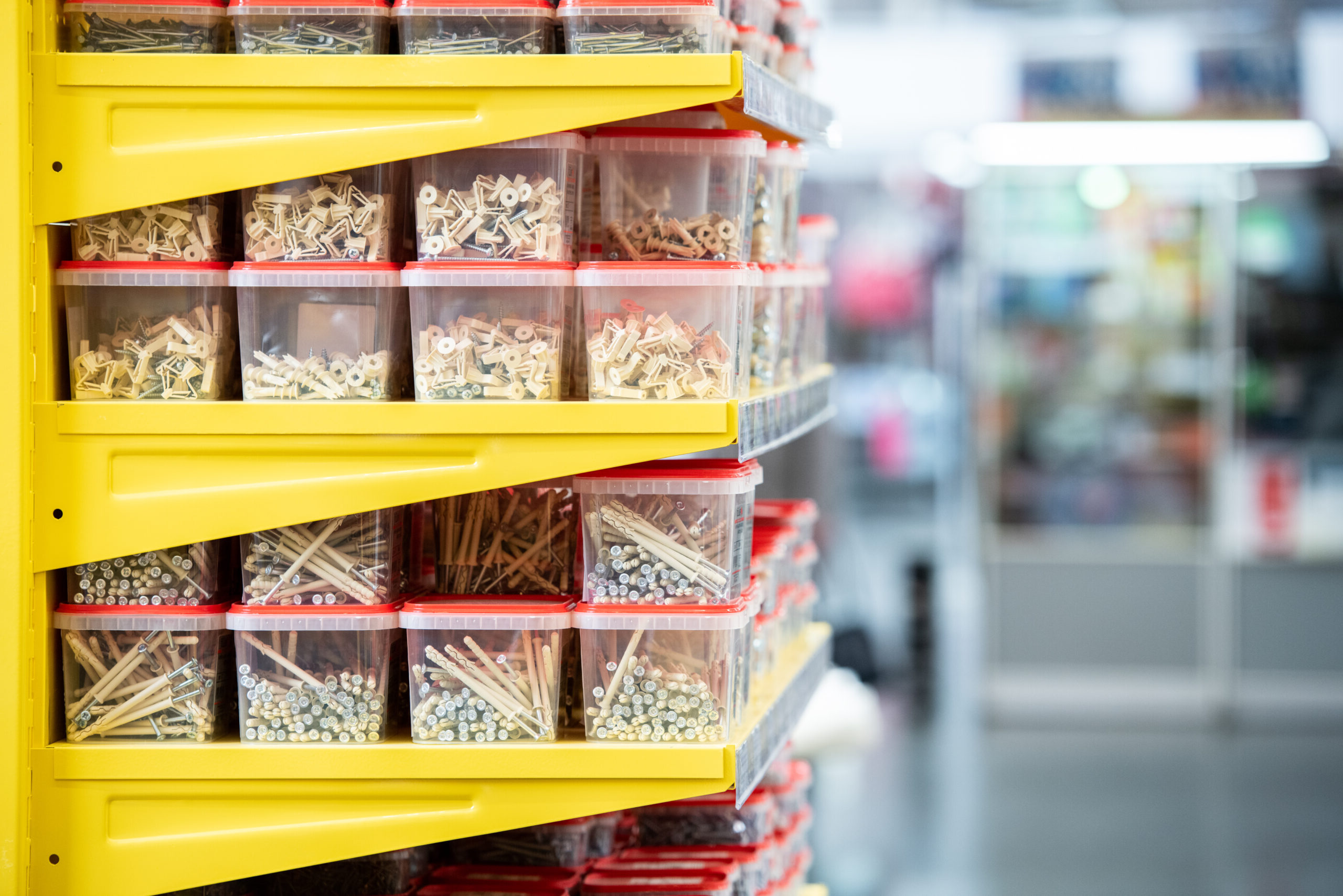 Side view of shelves with stacks of plastic containers with nails